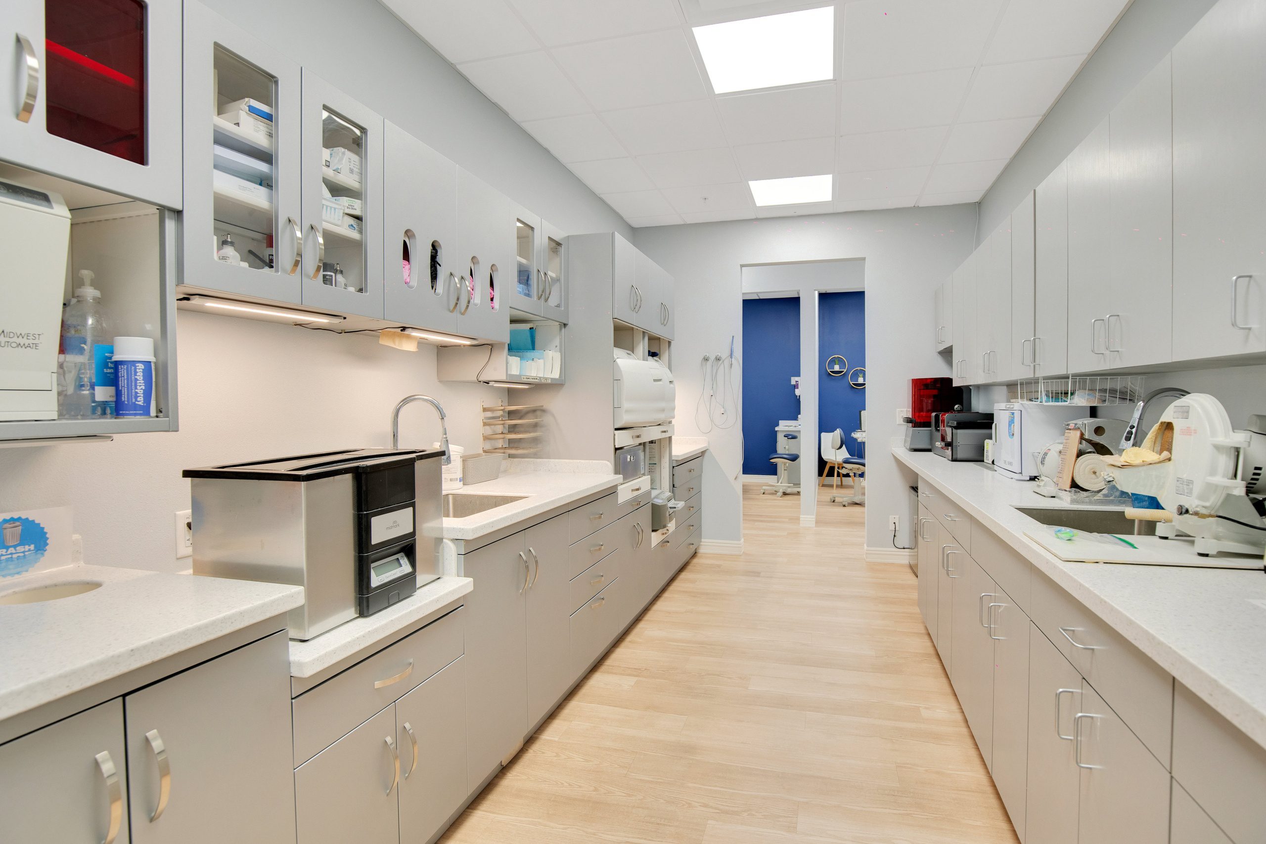 Clean, well-lit laboratory with white countertops, and wood-like flooring.