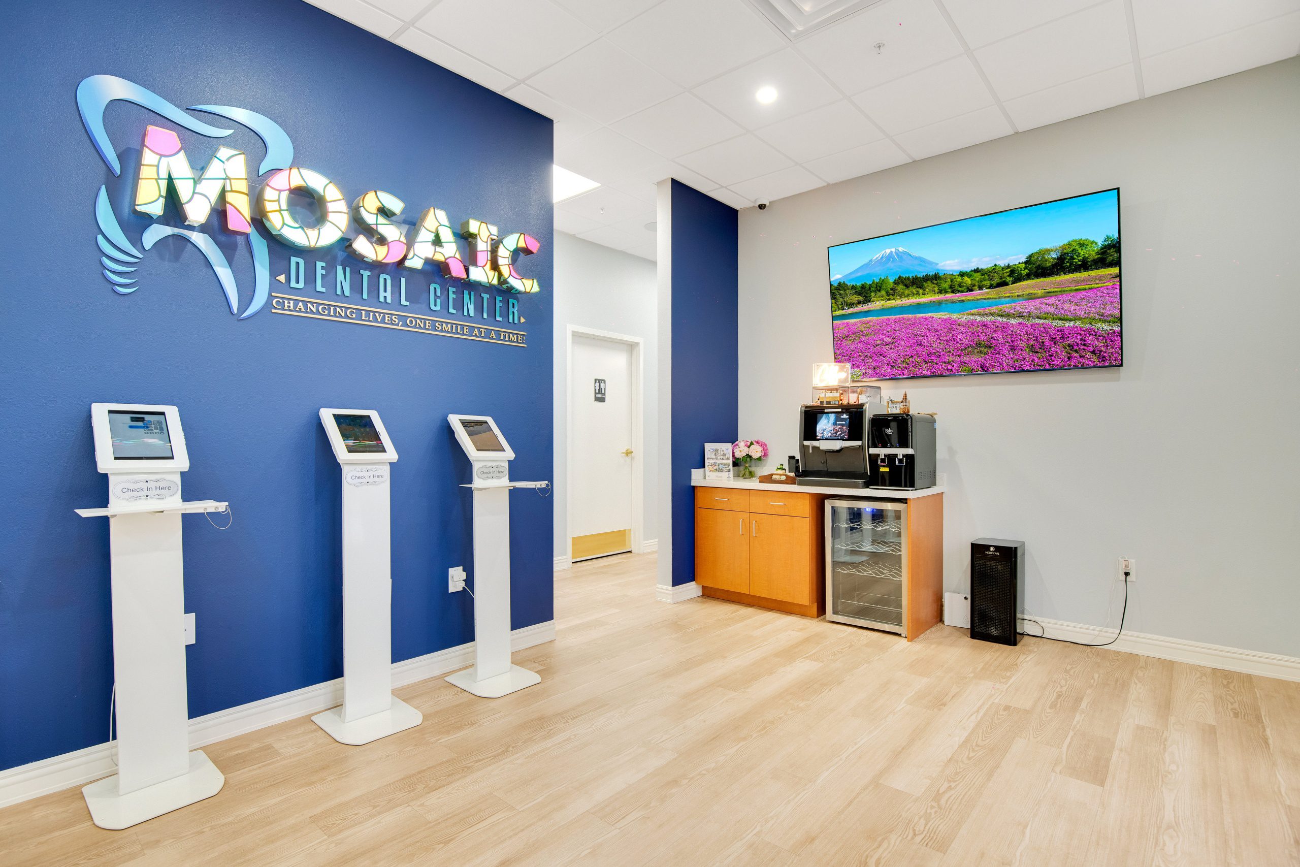 Interior of a modern dental clinic with a blue wall featuring a mosaic dental center